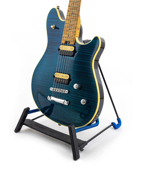 Blue Peavey EVH Wolfgang Standard Hardtail guitar displayed on a black stand, highlighting its striking appearance.
