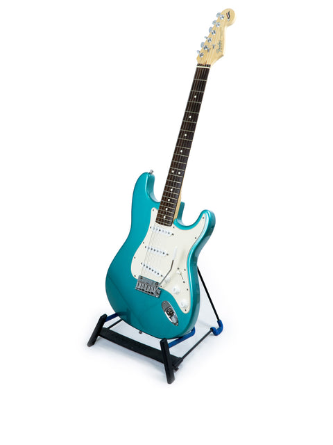 Blue electric guitar, a Fender 40th Anniversary Stratocaster, displayed on a stand with a clean white backdrop.