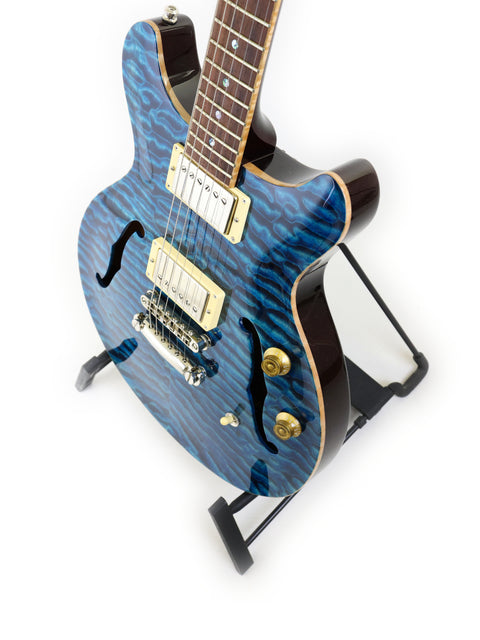 Blue electric guitar with a wavy pattern on a white background.
