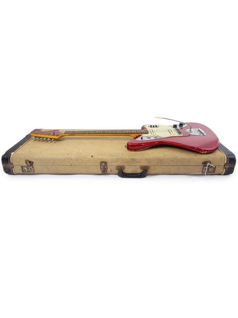 Candy Apple Red 1964 Fender Jaguar guitar showcased in a suitcase, set against a white background.