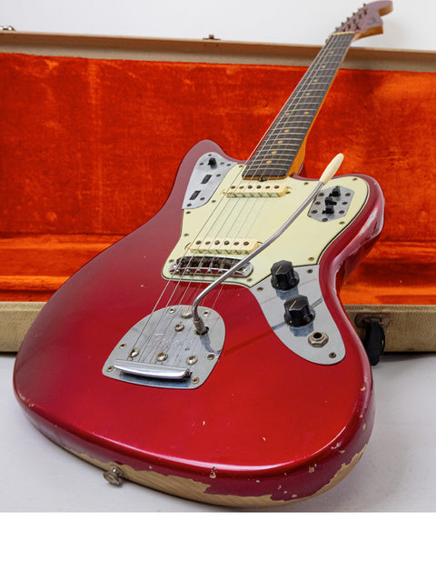 Candy Apple Red 1964 Fender Jaguar guitar with its case, lying on the floor, highlighting its classic design.