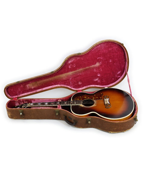 Classic 1954 Gibson J-200 guitar in its case, prominently featured on a white background, highlighting its vintage appeal.