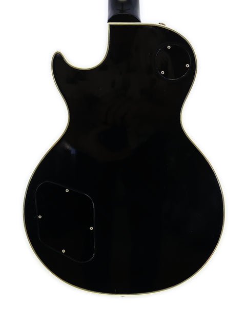 Classic black electric guitar, a 1972 Gibson Les Paul Custom, with a contrasting white pickguard.