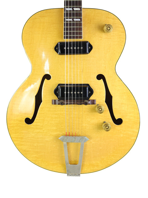 Classic yellow Gibson ES-300 guitar from 1952, complete with a black pick guard, representing vintage American craftsmanship.
