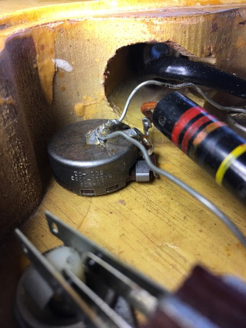 Close-up image of a 1958 Gibson Les Paul Special guitar, surrounded by wires and tools, emphasizing its classic design.