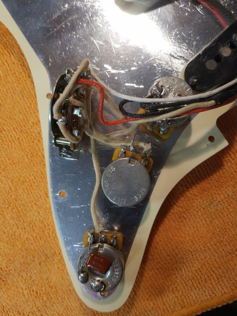 Close-up of a 2012 Warmoth Strat Partscaster guitar, highlighting its pickup and wires, perfect for music enthusiasts.