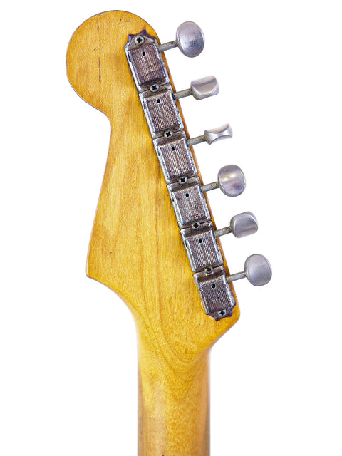 Close-up of a Fender L-Series Stratocaster headstock, showcasing its wooden body and classic design from 1963.