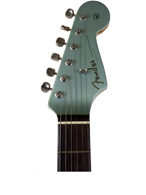 Close-up of a Fender Stratocaster guitar headstock against a white background.