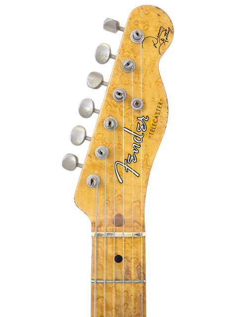 Close-up of a Fender Telecaster guitar headstock with six tuning pegs and a wood grain finish.