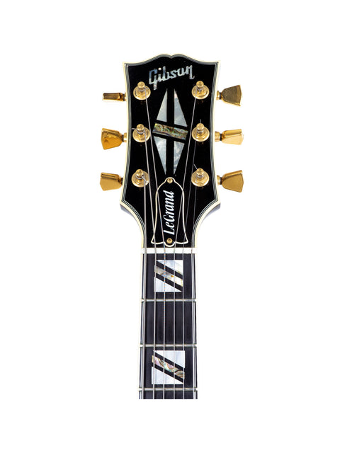 Close-up of a Gibson Custom Shop Le Grand Archtop guitar with a sleek black headstock, showcasing its craftsmanship.