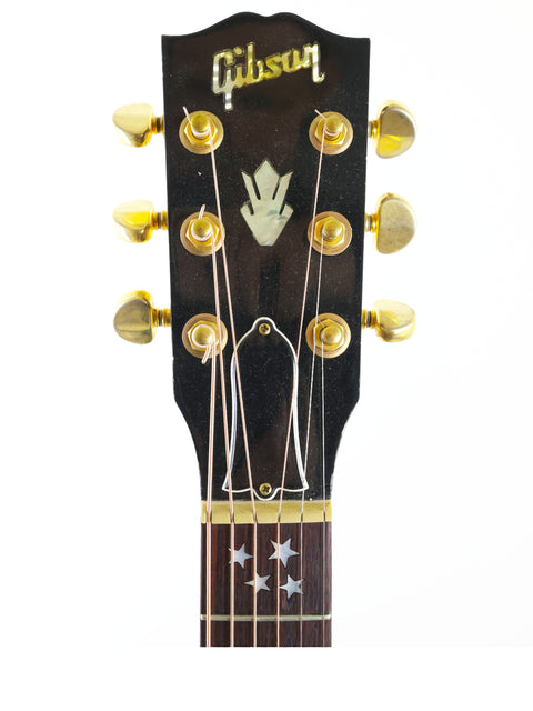 Close-up of a Gibson J-180EC acoustic guitar headstock, showcasing its intricate design and craftsmanship from 2001.