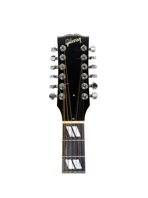 Close-up of a Gibson J-185-12 string guitar with a striking black headstock, highlighting its elegant features and USA craftsmanship.
