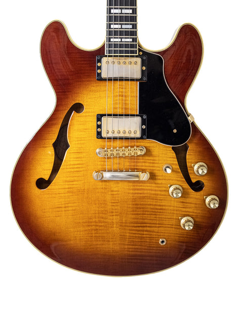 Close-up of a Gibson electric guitar featuring a vibrant sunburst finish, highlighting its design and Japanese craftsmanship from 2004.
