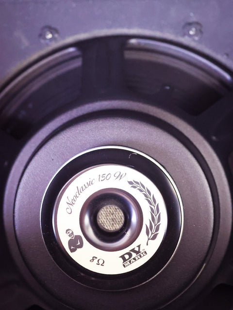 Close-up of a speaker with "Neoclassic 150 W" label and 8-ohm impedance mark.