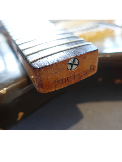 Close-up of a vintage 1963 L Series Stratocaster guitar, featuring its beautifully crafted wooden bridge.