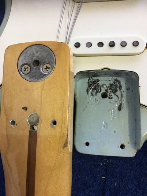 Close-up of a vintage 1972 Fender Stratocaster with a noticeable hole in the back, showcasing its unique refinishing.