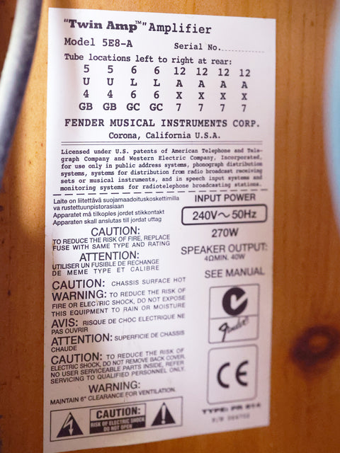 Close-up of a wooden cabinet label reading "1957 Fender Twin Reissue Amp 2006 - USA," showcasing its vintage appeal.