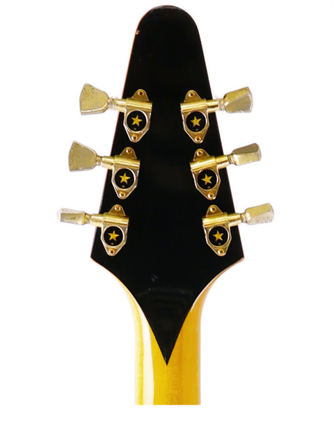Close-up of an Ibanez 2387CT Rocket Roll Sr. Flying V guitar headstock, featuring a striking yellow and black design.