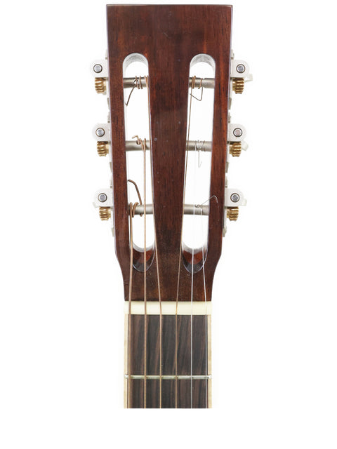 Close-up of an acoustic guitar's headstock with tuning pegs, featuring Gilet Bay State, Australia, in the background, 2018.
