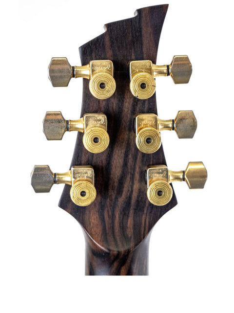 Close-up of the headstock of a 2004 Ed Roman Quicksilver electric guitar, showcasing its PRS-style design and craftsmanship.
