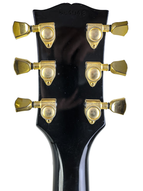 Close-up shot of a 1969 Gibson Les Paul Custom headstock, emphasizing its iconic shape and vintage appeal.