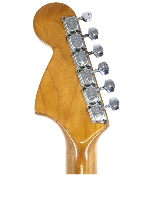 Close-up shot of a 1979 Fender Stratocaster guitar head, featuring a beautifully crafted wooden body and vintage appeal.