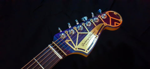 Close-up shot of a striking guitar headstock, featuring bright colors, from the Zachary & Mercer Mastermind “Royal” Offset.

