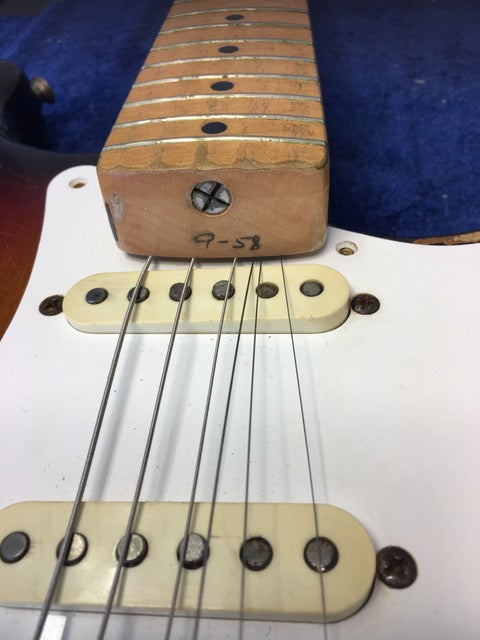 Close-up shot of a vintage 1958 Fender Stratocaster, focusing on the pickup and craftsmanship.
