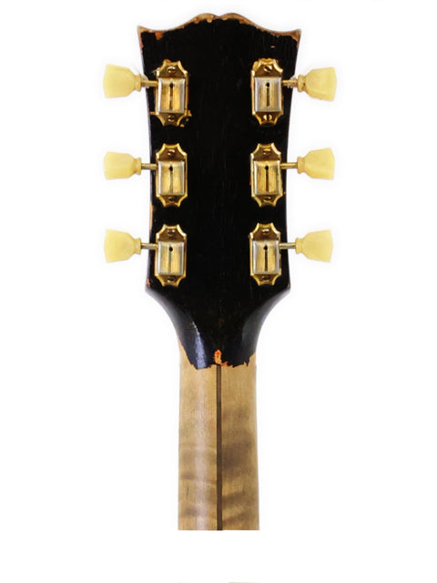 Close-up shot of the headstock from a 1954 Gibson J-200 acoustic guitar, emphasizing its vintage style and intricate details.