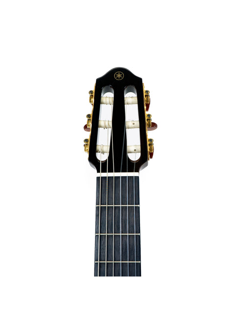 Close-up view of a Yamaha SLG 120NW Silent Guitar, highlighting its black body and striking gold hardware.