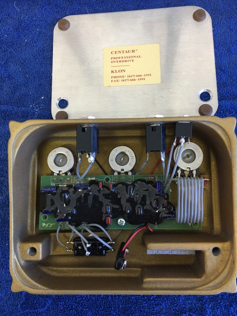 Compact electronic device with wires and a box, showcasing the original Klon Centaur "Horsie" logo, USA 1997.
