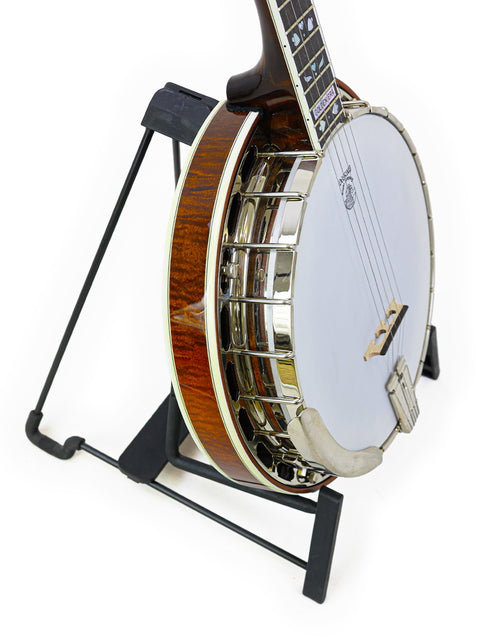 Deering Golden Era Banjo, made in the USA in 2008, sits on a stand alongside a guitar, emphasizing its classic appeal.