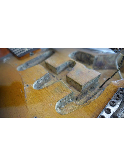 Detailed view of a 1963 USA L Series Stratocaster guitar featuring a broken neck, highlighting its vintage wear and tear.
