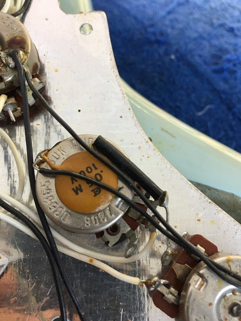 Detailed view of a 1972 Fender Stratocaster electric guitar, featuring wires and a cap, highlighting its vintage appeal.