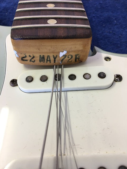 Detailed view of a 1972 Fender Stratocaster guitar, featuring its pickup and strings, emphasizing its vintage appeal.