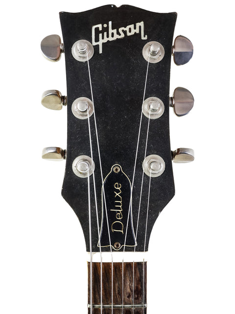 Detailed view of a 1973 Gibson Les Paul Deluxe headstock, emphasizing its vintage style and refinished condition.