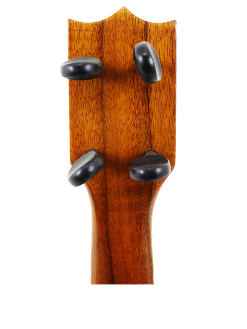 Detailed view of a vintage Royal Style 3 Koa Ukulele, c. 1916, highlighting the rich wood grain of its body.