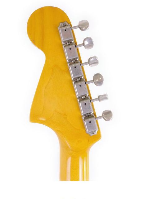 Detailed view of a yellow-bodied Fender CIJ Jaguar guitar headstock, highlighting its features and vintage appeal from Japan, 1999-02.