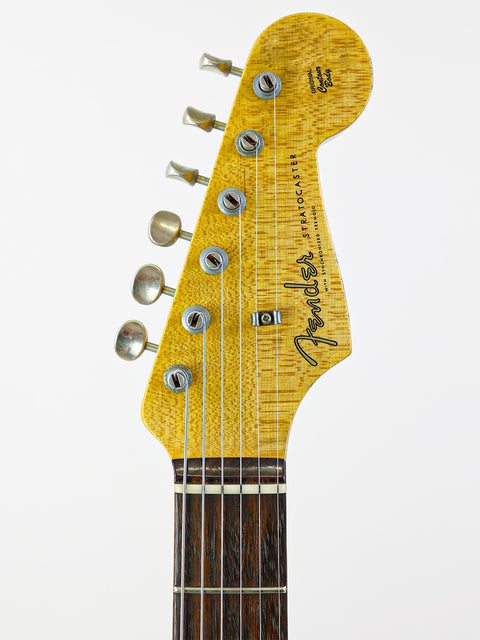 Detailed view of a yellow-bodied Fender Custom Shop '59 Stratocaster headstock, highlighting its unique design and quality.
