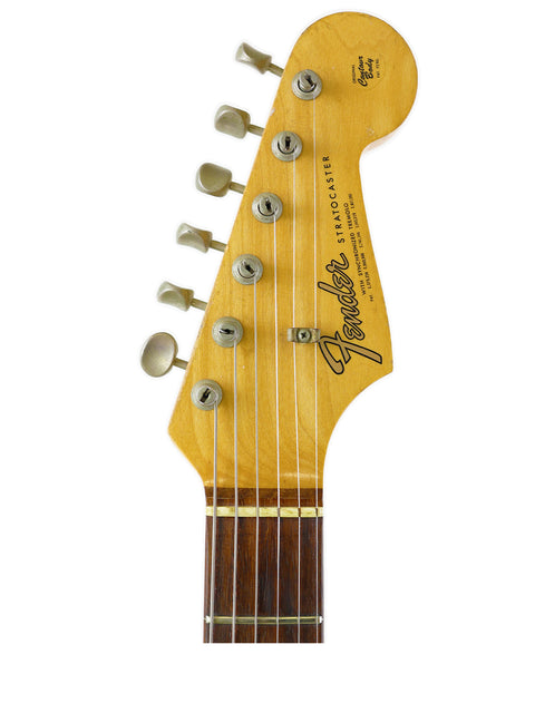 Detailed view of the headstock from a 1965 USA Fender Stratocaster electric guitar, highlighting its iconic shape and features.