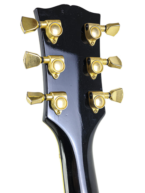 Detailed view of the headstock from a 1969 Gibson Les Paul Custom, highlighting its vintage features and iconic logo.