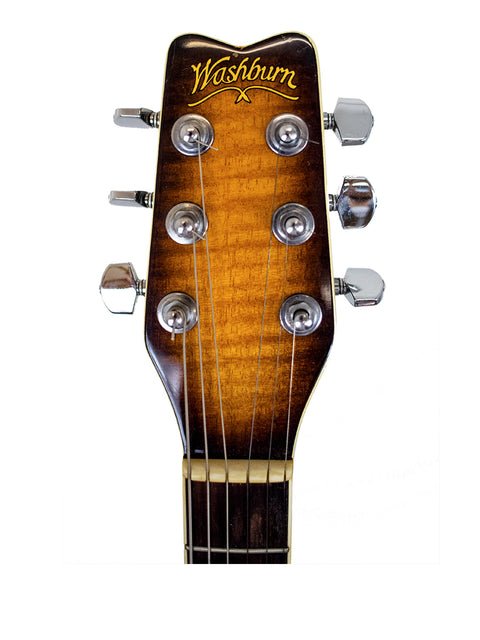 Detailed view of the headstock from a 1984 Washburn Mirage Deluxe acoustic guitar, highlighting its vintage elegance and features.