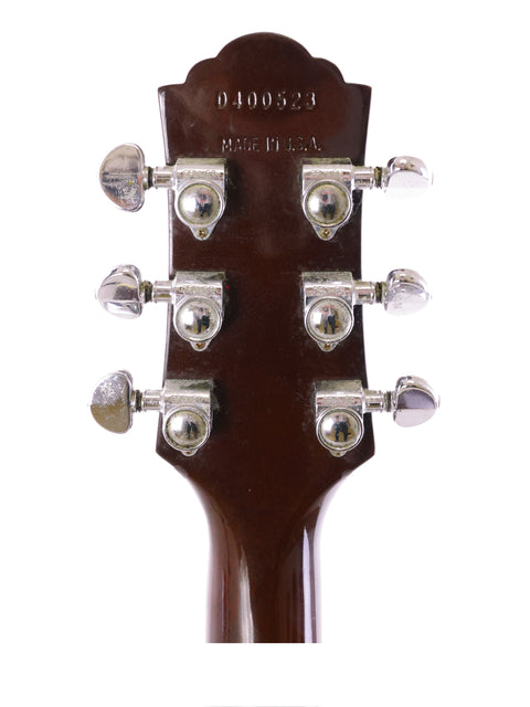 Detailed view of the headstock of a 1989 Guild D40 acoustic guitar, highlighting its craftsmanship and tuning mechanisms.