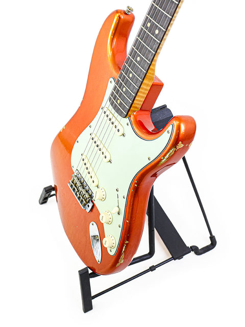 Display of a Fender Ltd NAMM '64 Stratocaster Relic guitar on a stand, featuring a pure white background.