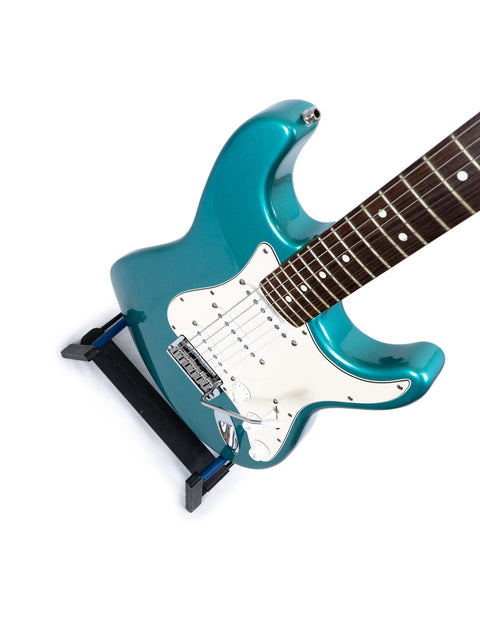 Displayed on a stand, a blue Fender 40th Anniversary American Standard Stratocaster electric guitar from 1994.