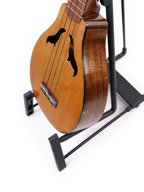 Elegant 1927 Harmony Roy Smeck Vita-uke ukulele on a stand, a timeless piece for collectors and music lovers alike.