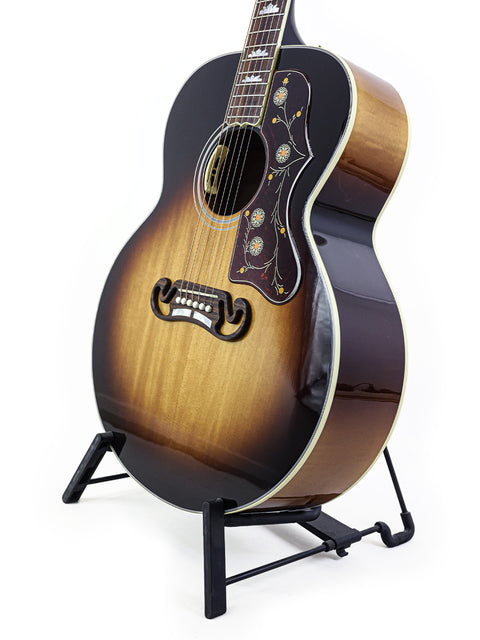 Elegant Gibson SJ-200 guitar on a stand, set against a bright white background. A must-have for any serious musician.