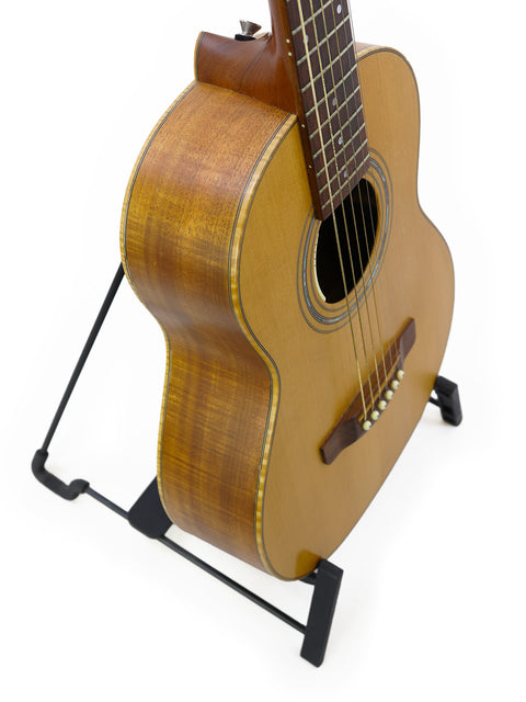 Elegant Gilet Travel SS Guitar displayed on a stand, highlighting its craftsmanship against a bright white backdrop.