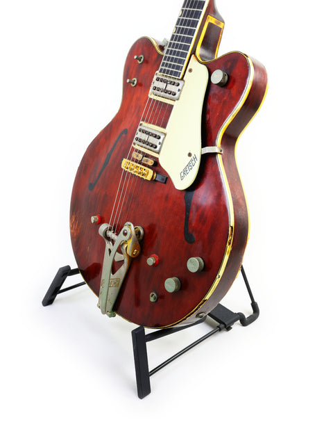 Eye-catching red Gretsch 6122 guitar on a stand, ideal for adding style to your music collection or performance setup.