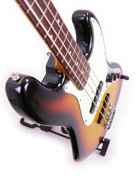  Fender Custom Shop '64 Jazz Bass Relic from 2006, featuring a sleek black body and a striking sunburst finish.